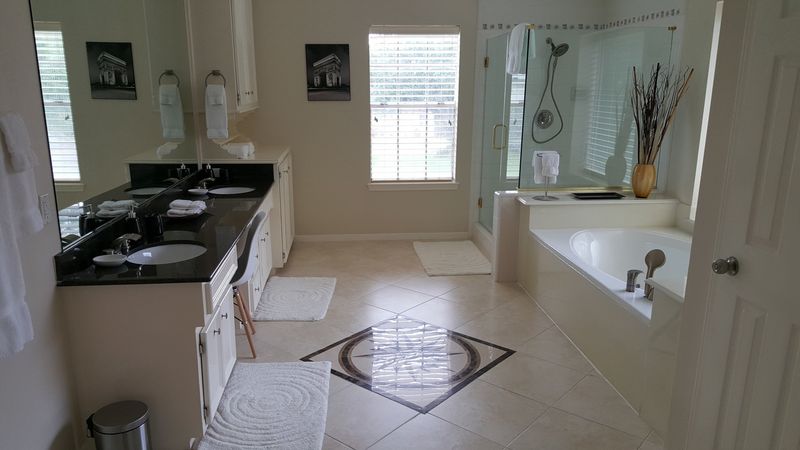 Bathroom with two sinks, a bathtub, and a shower