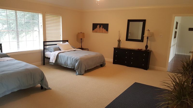 Bedroom with two beds, a dresser, and a mirror